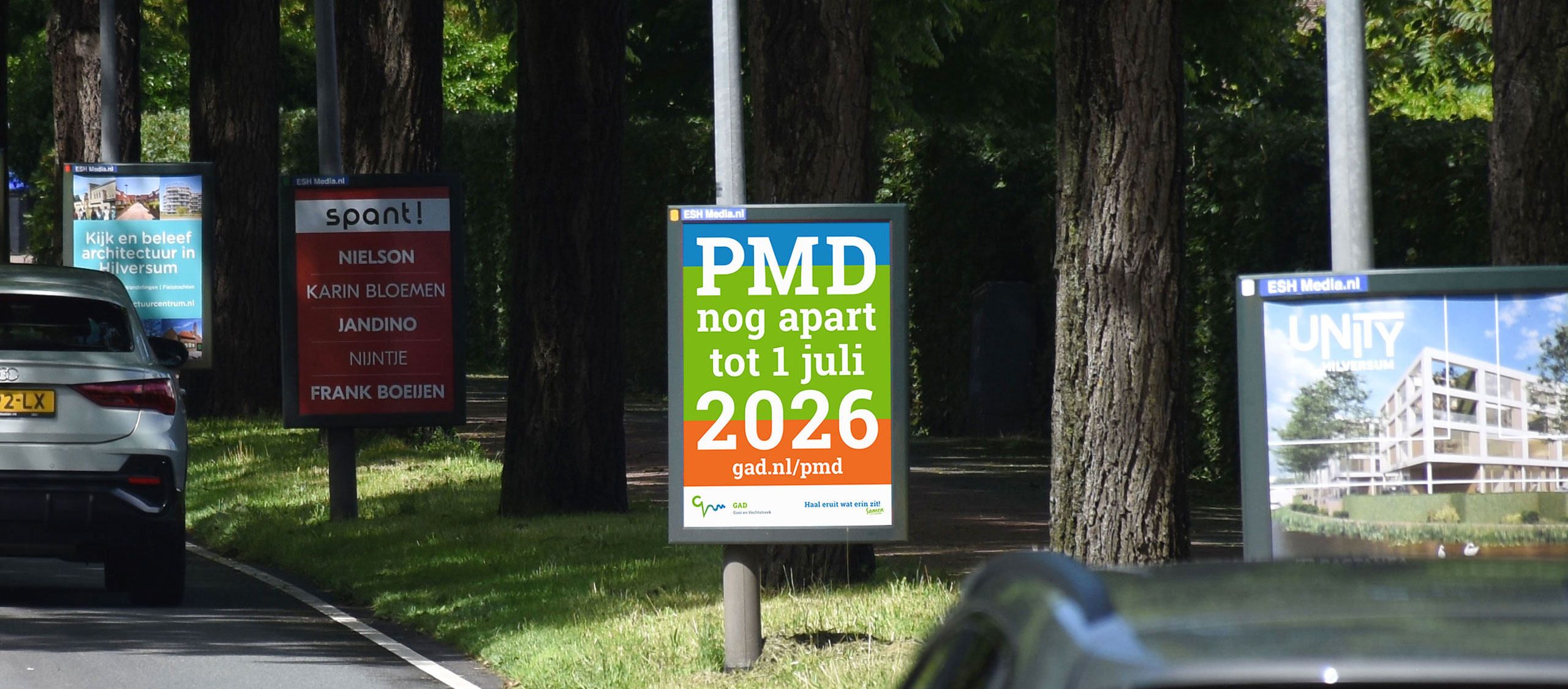 HSTotaal: opvallende abri poster tussen donkere bomen langs de Diependaalselaan in Hilversum van de GAD over PMD-scheiding